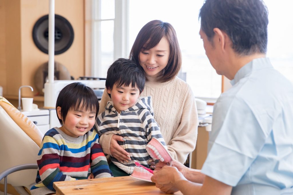歯磨き指導を受けている親子