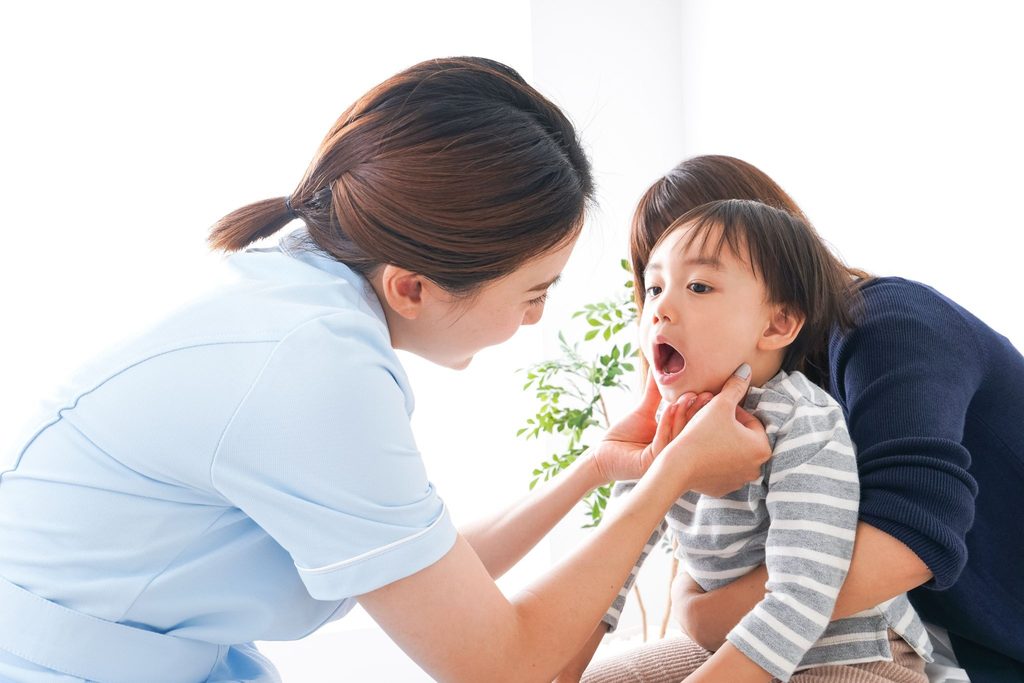 子どもの歯をチェックしている歯科医療従事者の女性