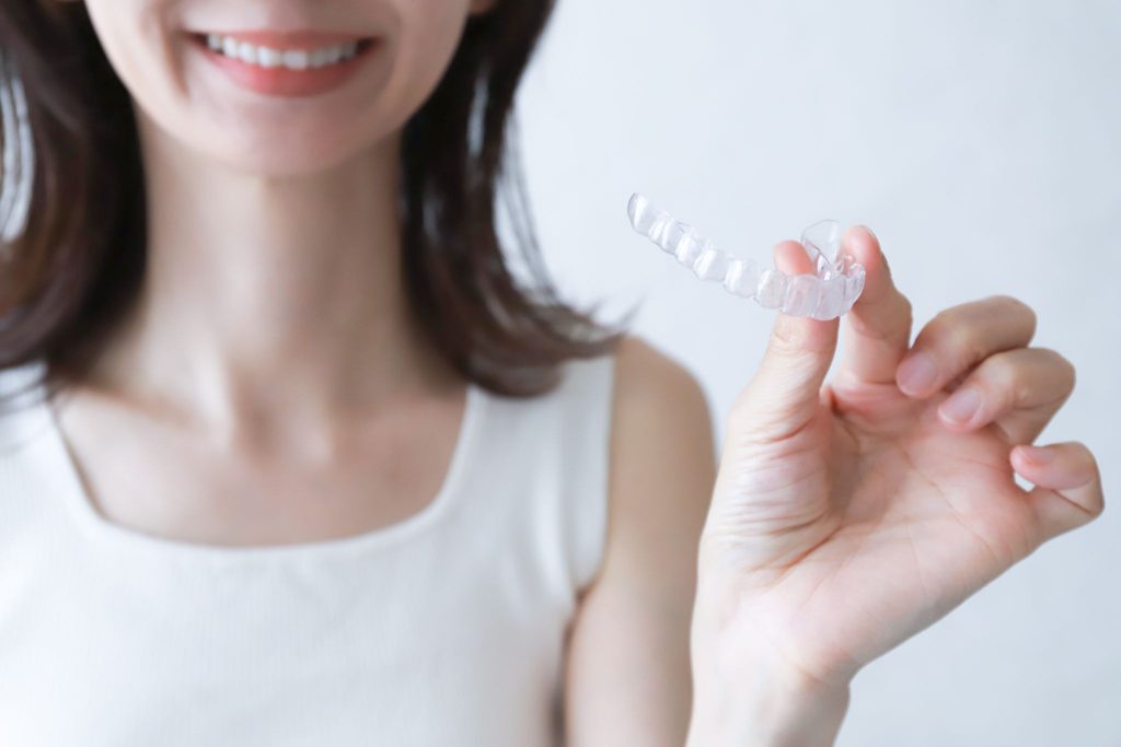 マウスピース矯正装置を持つ女性