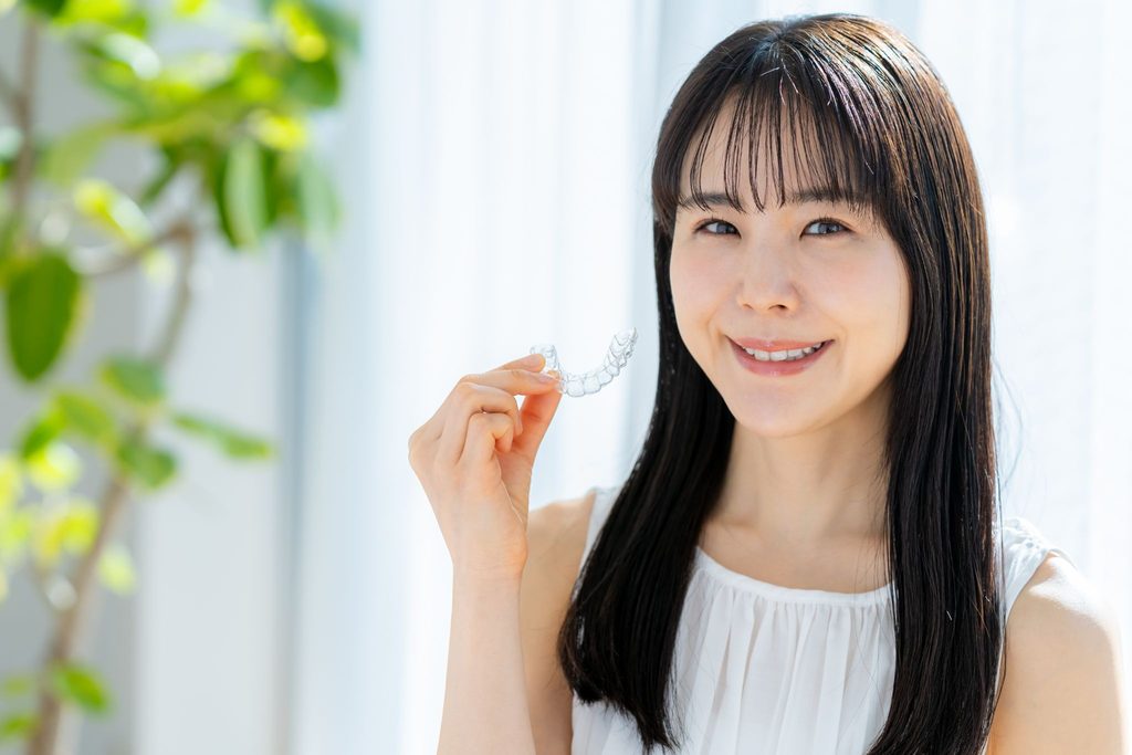 マウスピース矯正装置を持つ女性