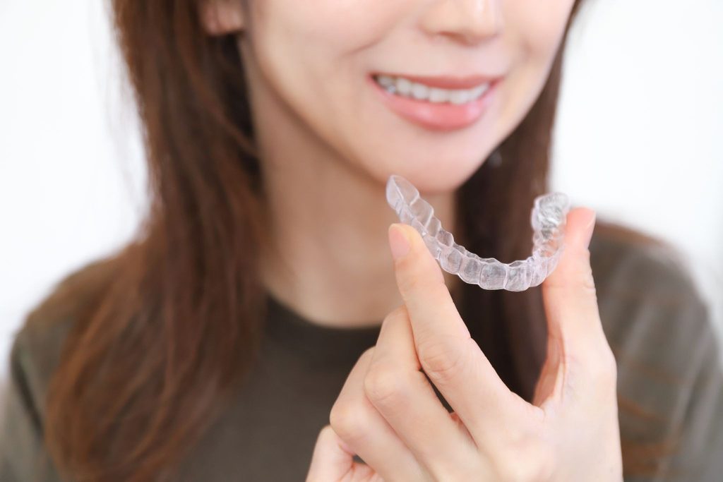マウスピース矯正装置を持つ女性