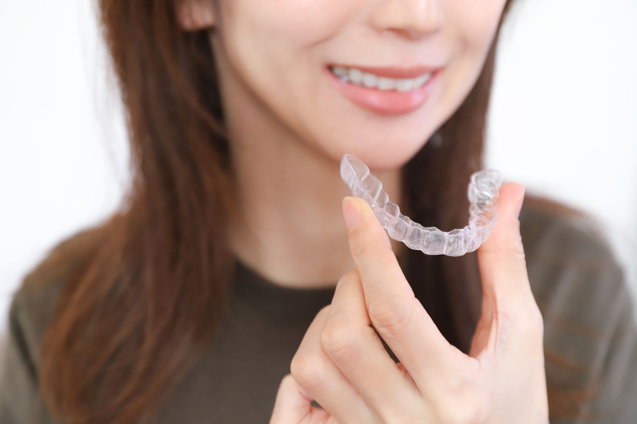 マウスピース矯正装置を持つ女性