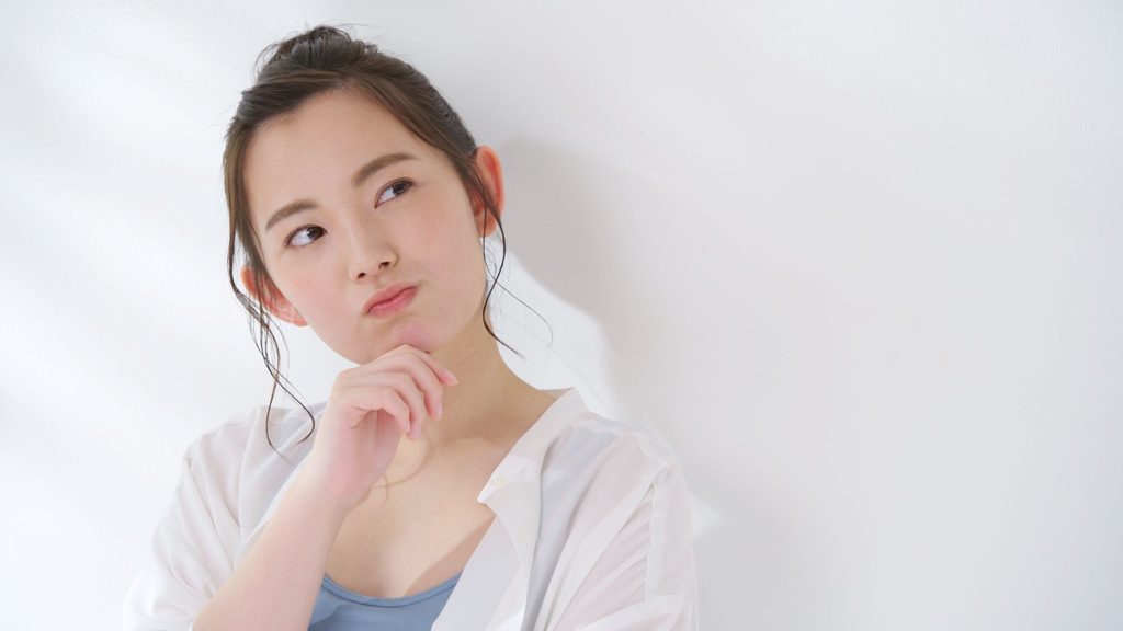 手を顎に当てて首を傾げている女性