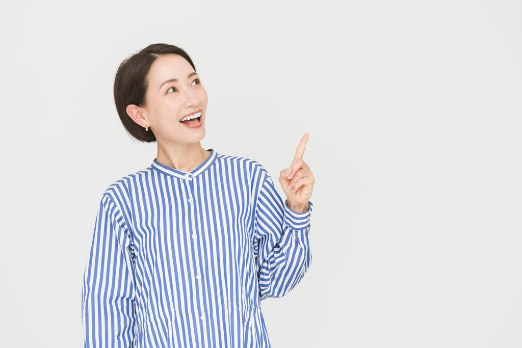 人差し指を立てて笑顔の女性