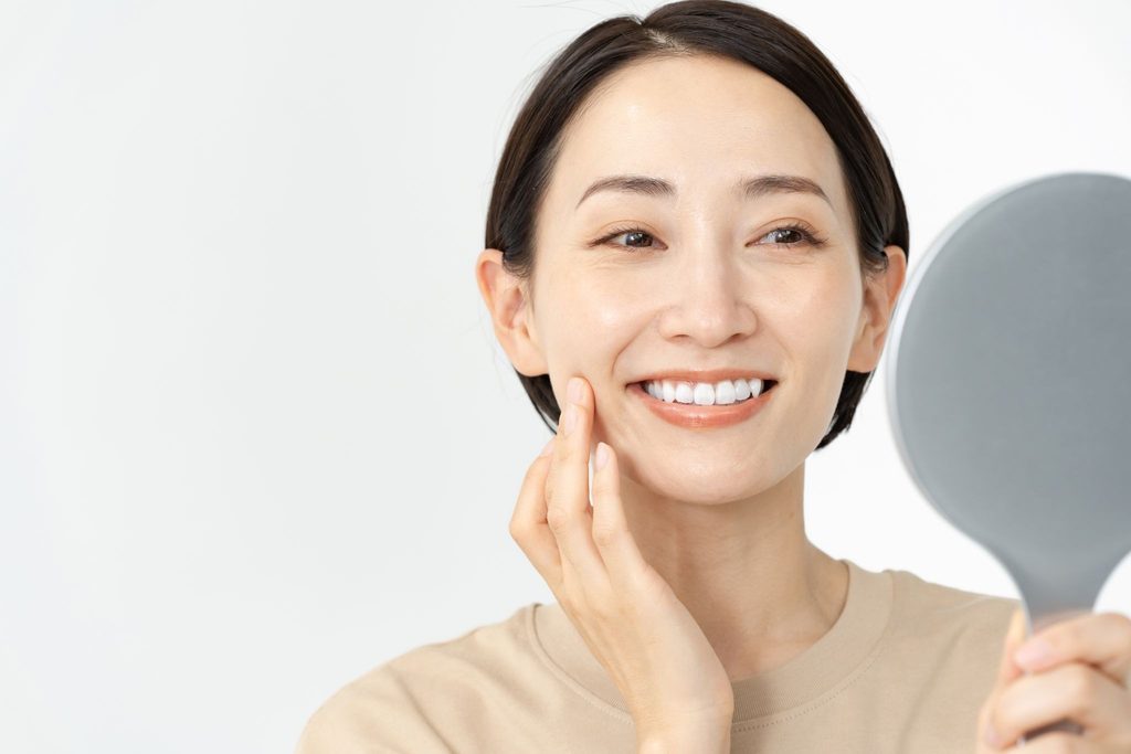 笑顔で鏡を見る女性